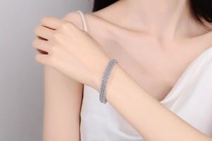 Close-up of S925 sterling silver bangle with triple row moissanite on model wrist