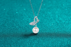 Close-up of S925 silver butterfly pendant with moissanite, crystals and a white pearl
