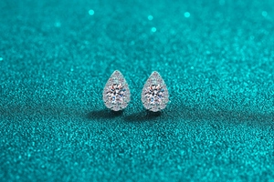 Macro shot of S925 sterling silver halo stud earrings with pear-shaped drops and crystals