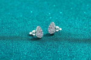 Macro detail of pear-shaped S925 silver earrings with sparkling halo moissanite