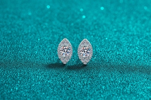 Macro view of marquise-shaped silver halo stud earrings with brilliant moissanite stones