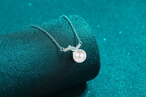 Dettaglio elegante collana in argento S925 con perla bianca tonda e pietre lucenti