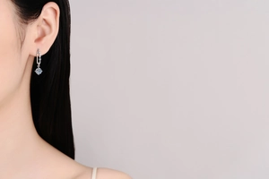 Close-up of S925 silver paperclip drop earrings with moissanite stones on model