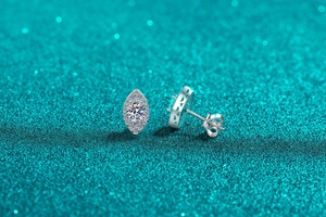 Macro shot of S925 sterling silver oval stud earrings with moissanite halo and hollow pattern
