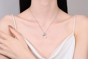 Close-up of S925 silver pearl necklace with butterfly pendant on model's neckline