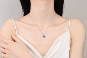 Detail view of S925 sterling silver necklace with square blue moissanite on model