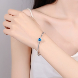 S925 sterling silver heart bracelet featuring a bright blue moissanite gemstone centerpiece