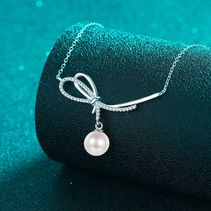 S925 silver bow necklace with moissanite diamond and pearl pendant on green stand