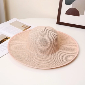 Elegant light pink wide brim woven straw sun hat for summer beach vacations and UV protection