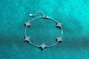 Detail of S925 silver five-clover bracelet with shimmering moissanite star charms