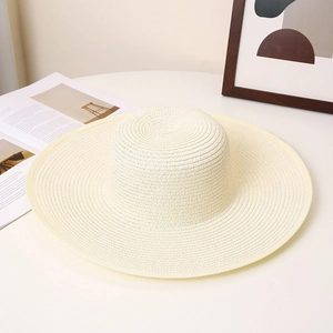 Elegant cream-white woven straw sun hat with wide flat brim and minimalist dome style