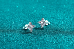 Macro shot of silver four-leaf clover stud earrings with sparkling round-cut crystals