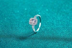 Vue latérale d'une bague moissanite de taille émeraude avec serti pavé de diamants