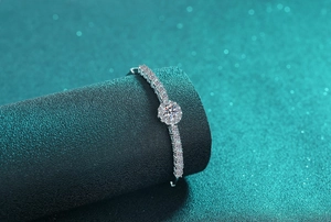 Detailed view of S925 sterling silver bracelet with moissanite flower on green background