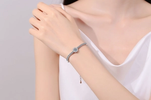 Macro detail of S925 sterling silver moissanite bracelet on a wrist with silk clothing