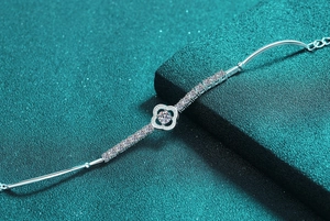 Macro shot of silver clover bracelet featuring moissanite center and micro-pave detailing