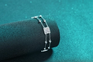 Detail of S925 silver double-chain bracelet featuring square moissanite and round charms