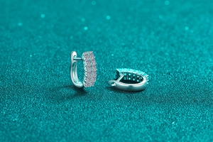 Macro shot of S925 sterling silver huggie earrings with triple-row moissanite inlay