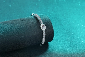 Macro shot of oval blue stone halo bracelet with silver diamond chain on a pedestal