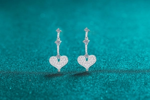 Macro view of S925 silver heart drop earrings with shimmering pavé moissanite stones