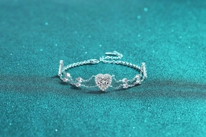 Detailed view of heart-shaped moissanite bracelet with halo setting and double-layer silver chain