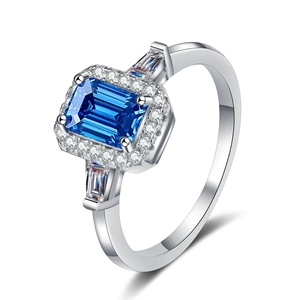 Bague élégante en argent 925 avec moissanite bleue taille émeraude et halo sous un angle de 45°