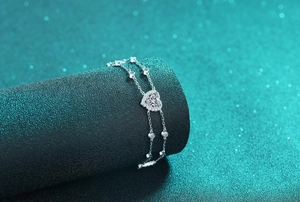 Detailed macro view of S925 silver double layer bracelet with sparkling heart charm