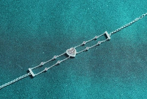 Macro detail of S925 silver heart bracelet featuring a sparkling moissanite center stone