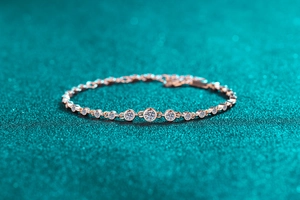 Macro shot of rose gold S925 silver bracelet with sparkling moissanite on blue background