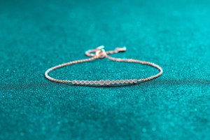 Close-up of rose gold moissanite bracelet with adjustable bolo clasp and stones