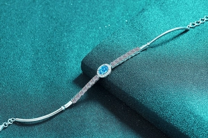 Macro detail of S925 silver bracelet with oval blue moissanite and pave diamonds