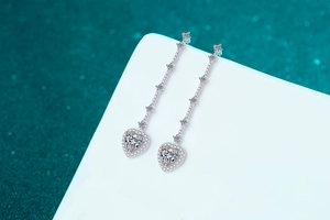 Detailed macro view of S925 sterling silver heart-shaped tassel earrings with moissanite