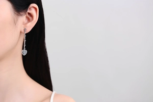 Close-up of S925 silver long heart tassel earrings with moissanite on a female model