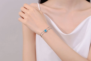Nahaufnahme von silbernem Armband mit blauem Saphir-Schliff und Pavee-Details für Damen