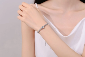 Detail of S925 sterling silver bracelet with halo-set moissanite on a woman's wrist