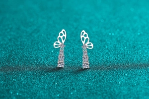 Detailed view of silver butterfly earrings with cascading brilliant round moissanite drops