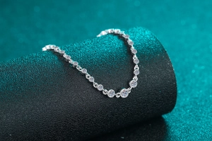 Macro shot of S925 silver bracelet with sparkling moissanite stones on dark green backdrop