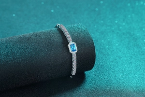 Macro detail of silver bracelet featuring a rectangular blue sapphire and pavé diamonds