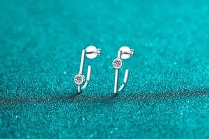 Macro shot of silver S925 geometric stud earrings with sparkling moissanite stones