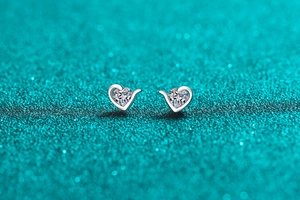 Macro shot of S925 sterling silver heart stud earrings with sparkling moissanite stones