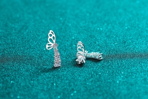 Detailed view of silver butterfly drop earrings with shimmering hanging moissanite stones