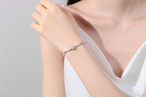 Macro shot of S925 sterling silver bracelet with square moissanite stone on woman's wrist
