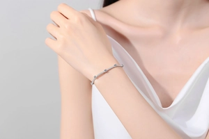 Detail of S925 sterling silver moissanite bracelet worn on wrist with silk sleeve