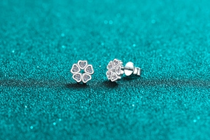 Macro detail of S925 sterling silver heart-shaped petal stud earrings with moissanite