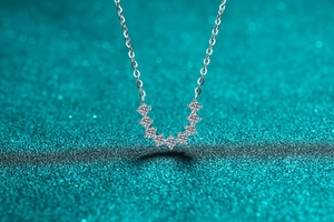 Close-up of S925 silver U-shape pendant with seven graduated moissanite stones