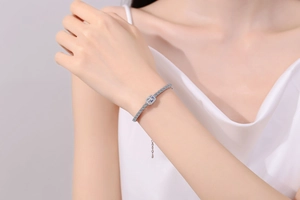 Detail of S925 sterling silver bracelet with emerald-cut moissanite worn on wrist