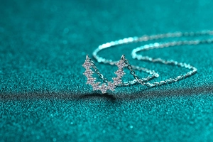 Macro shot of silver U-shaped pendant with seven sparkling round moissanite gemstones