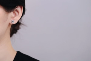 Detailed view of S925 sterling silver heart petal earrings on a model ear