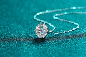 Macro shot of S925 sterling silver four-prong moissanite pendant on a fine silver chain