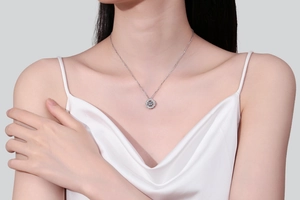 Close-up of S925 sterling silver four-prong moissanite pendant necklace on model neck